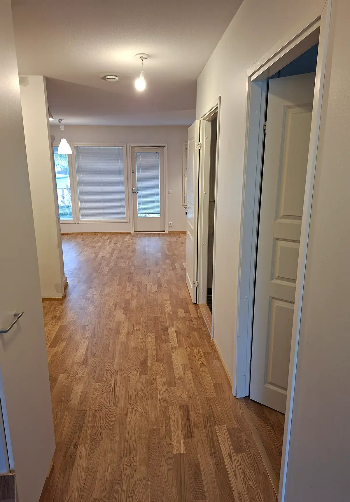 Asunnon käytävä remontin jälkeen – viimeistelty parkettilattia ja vaaleat maalatut pinnat.